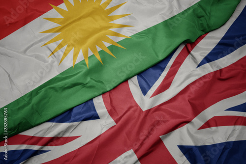 Bild auf Leinwand waving colorful flag of great britain and national flag of kurdistan