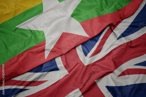 waving colorful flag of great britain and national flag of myanmar.