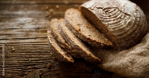 Konstfotografi Bread,  traditional spelled sourdough bread cut into slices on a rustic wooden background, close-up, top view, copy space