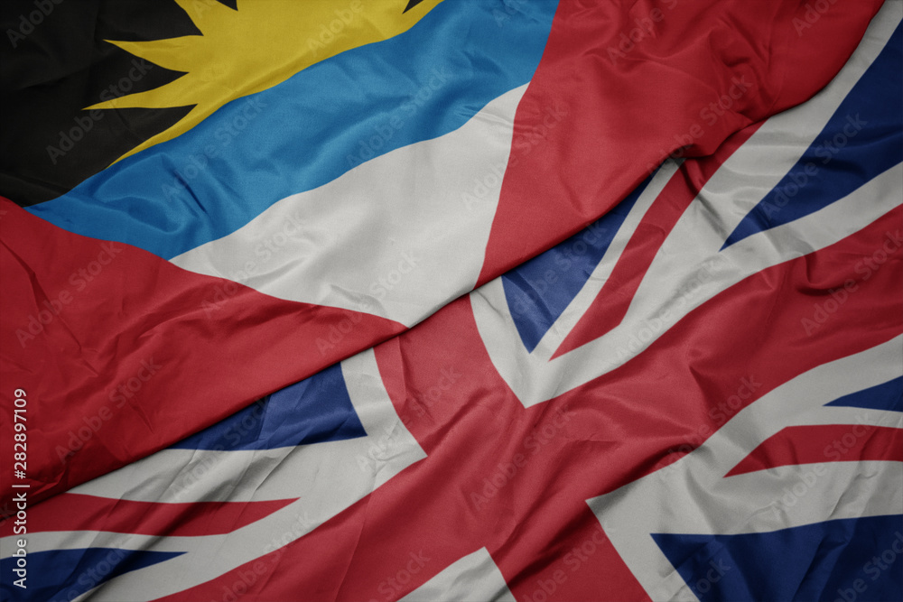 waving colorful flag of great britain and national flag of antigua and barbuda.