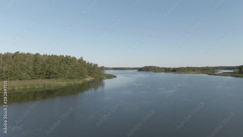 Flying over lake and island. River with ripples. Arial drone shot. Water and waves. Coast and wild forest. Flying over lake and island. River with ripples. Arial drone shot. Water and waves. Coast and wild forest.