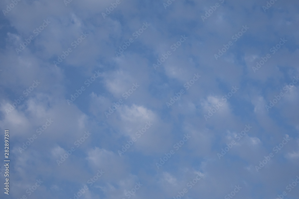 Blue sky background with grey and white clouds