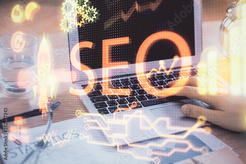 Double exposure of seo icon with man working on computer on background. Concept of search engine optimization.