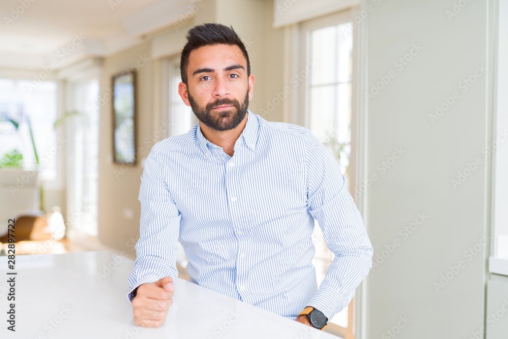 Handsome hispanic business man with serious expression on face. Simple and natural looking at the camera.