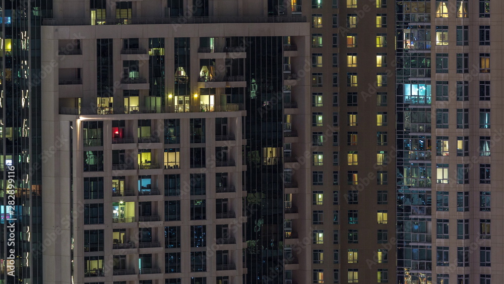 Windows of the multi-storey building with lighting inside and moving people in apartments timelapse. Windows of the multi-storey building with lighting inside and moving people in apartments timelapse.