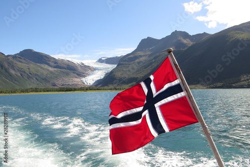 Norwegian Flag in front of the Western glacier (Engabreen) of the Svartisen (The Black Ice) glacier; access via ferry crossing Holand Fjord, Norway, Europe photo