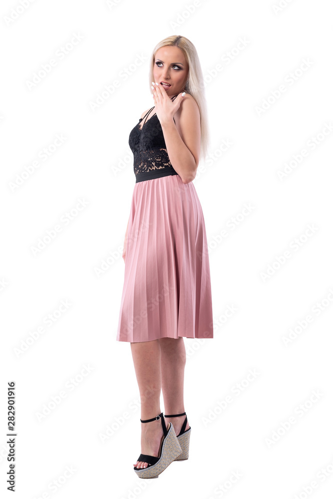 Surprised or shocked young woman with hand covering mouth looking up. Full body isolated on white background. 