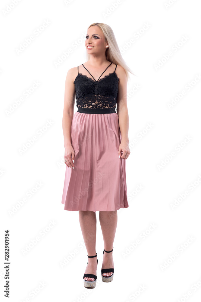 Happy young pretty blonde woman in long pleated skirt walking and looking up. Full body isolated on white background. Happy young pretty blonde woman in long pleated skirt walking and looking up. Full body isolated on white background.