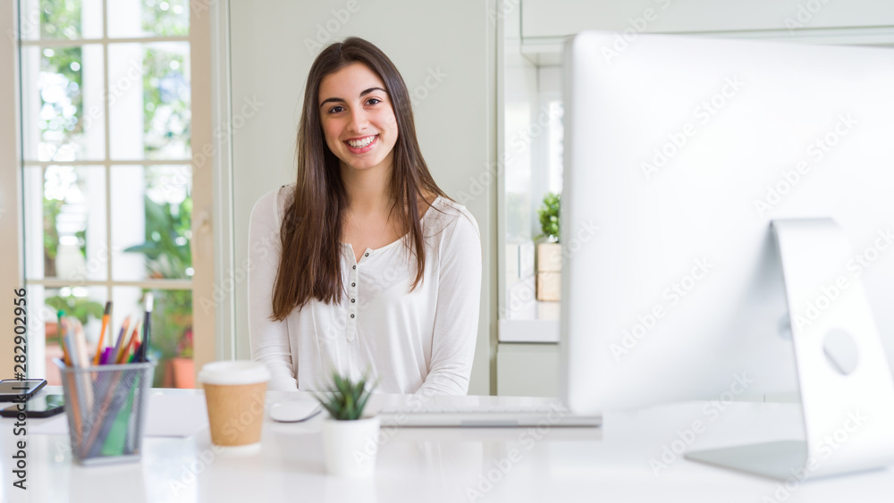 Beautiful young business woman working using computer, smiling and concentrated on online work Beautiful young business woman working using computer, smiling and concentrated on online work