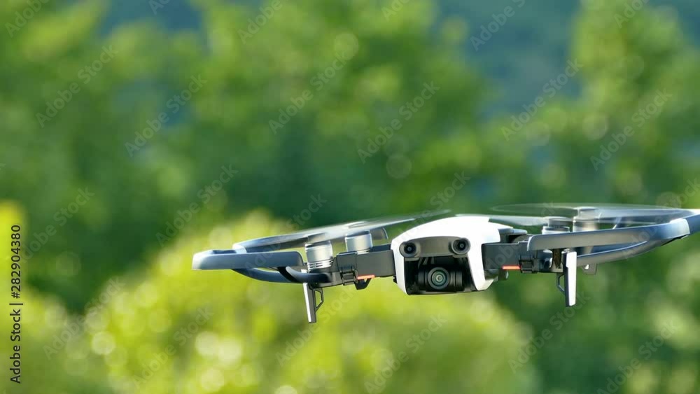 Quadrocopter in the air watching. Drone flies in nature on a green background. Filming from the air. Quadrocopter in the air watching. Drone flies in nature on a green background. Filming from the air.