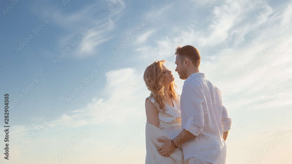 Love, romance, walk. Airy portrait of beautiful couple kissing on background of sunset sea, sandy beach and clouds. Love, romance, walk. Airy portrait of beautiful couple kissing on background of sunset sea, sandy beach and clouds.