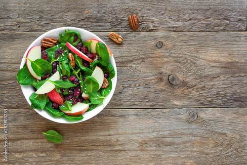 Spinach, apple salad with pecan nuts and dry cranberries