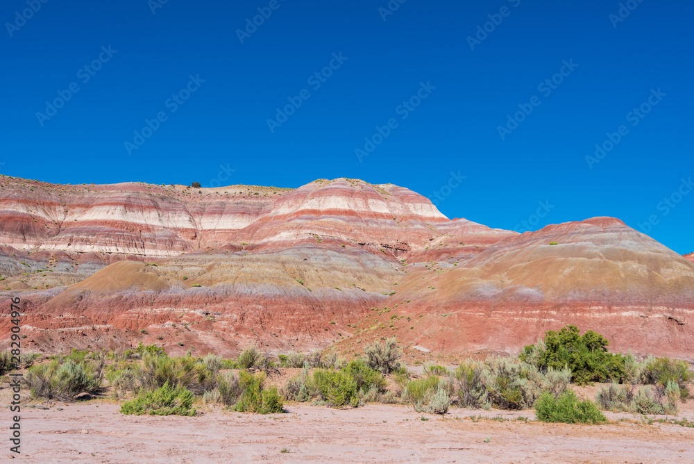Landscape of red, orange, pink and white striped or banded hills at Paria Canyon in Grand Staircase Escalante National Monument Landscape of red, orange, pink and white striped or banded hills at Paria Canyon in Grand Staircase Escalante National Monument