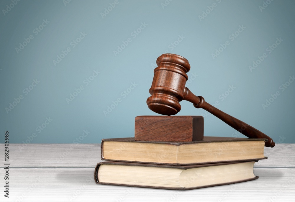 Justice Scales and books and gavel on wooden table Justice Scales and books and gavel on wooden table