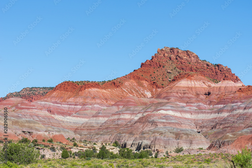 Landscape of red, orange, pink and white striped or banded hills at Paria Canyon in Grand Staircase Escalante National Monument