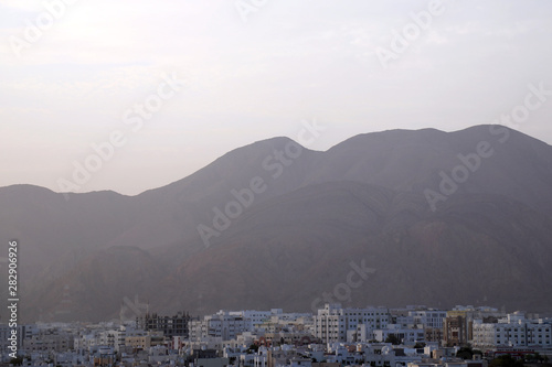 Dawn breaks over Muscat, capital of Oman, on 8 August 2017. The city is characterised by white-washed, low-rise houses and offices and is flanked by the Western Al Hajar mountains to the south. © Dominic Dudley
