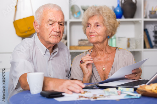 Serious senior couple counting bills