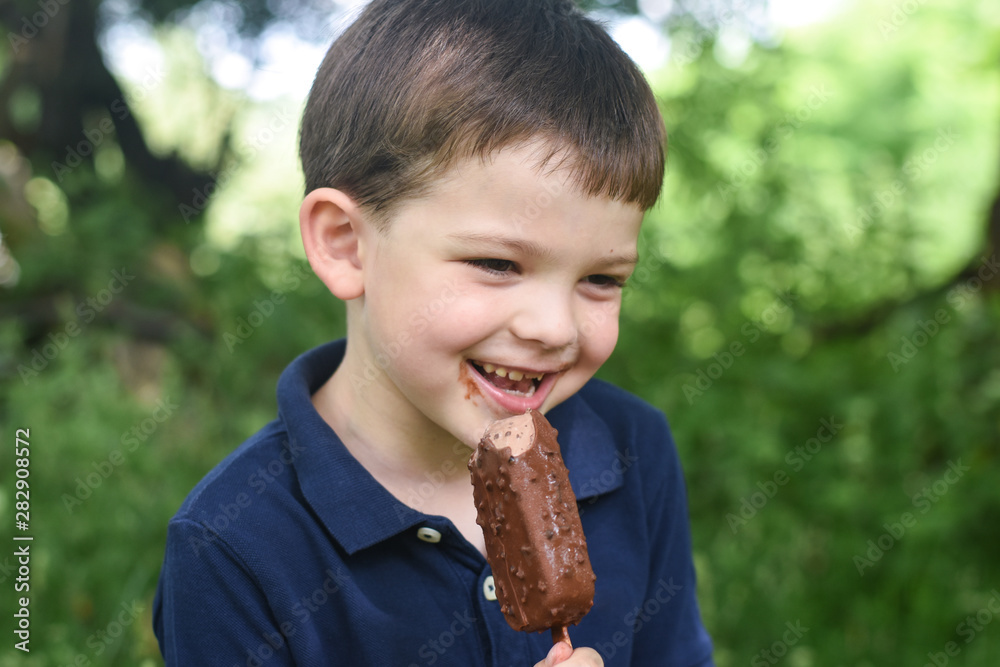Happy little boy eating ice cream. Summer refreshment, child with ice cream Happy little boy eating ice cream. Summer refreshment, child with ice cream