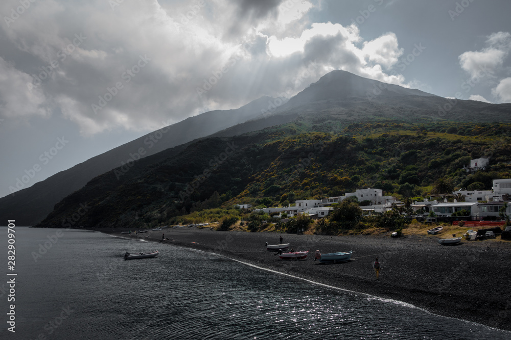 The volcano of stromboli seen from the harbor with covering clouds.