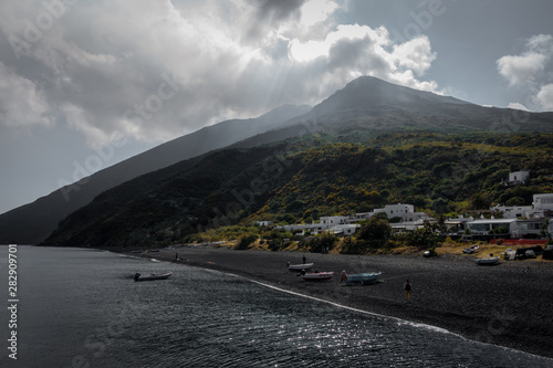 Obraz na płótnie The volcano of stromboli seen from the harbor with covering clouds. w salonie