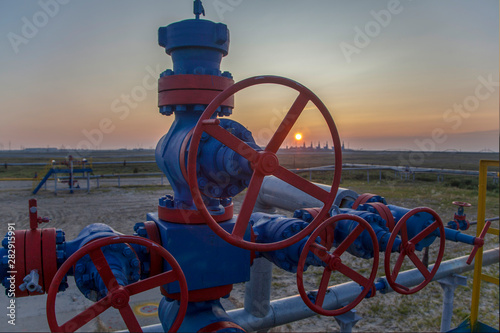 Group wellheads and valve armature , Gas valve, Gas well of high pressure, a wellhead with valve armature. Oil and gas industry concept. Industrial site background. Toned. photo