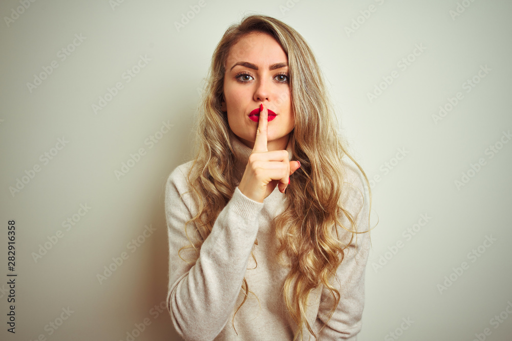 Beautiful woman wearing winter turtleneck sweater over isolated white background asking to be quiet with finger on lips. Silence and secret concept. Beautiful woman wearing winter turtleneck sweater over isolated white background asking to be quiet with finger on lips. Silence and secret concept.