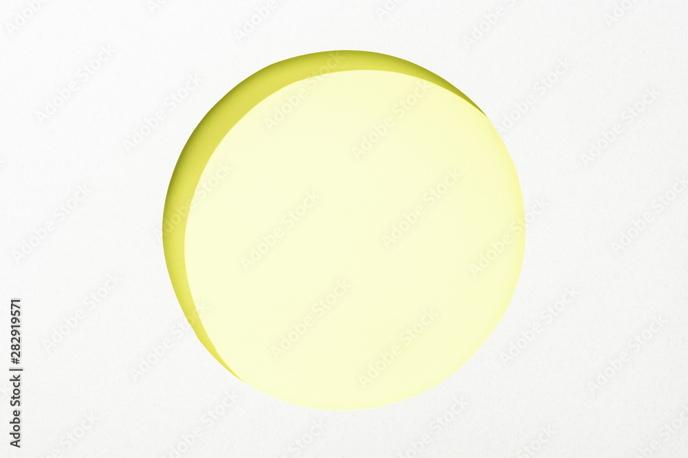 cut out round hole in white paper on lime green colorful background