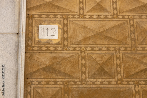 112, numero civico su casa con muro, antica  decorazione