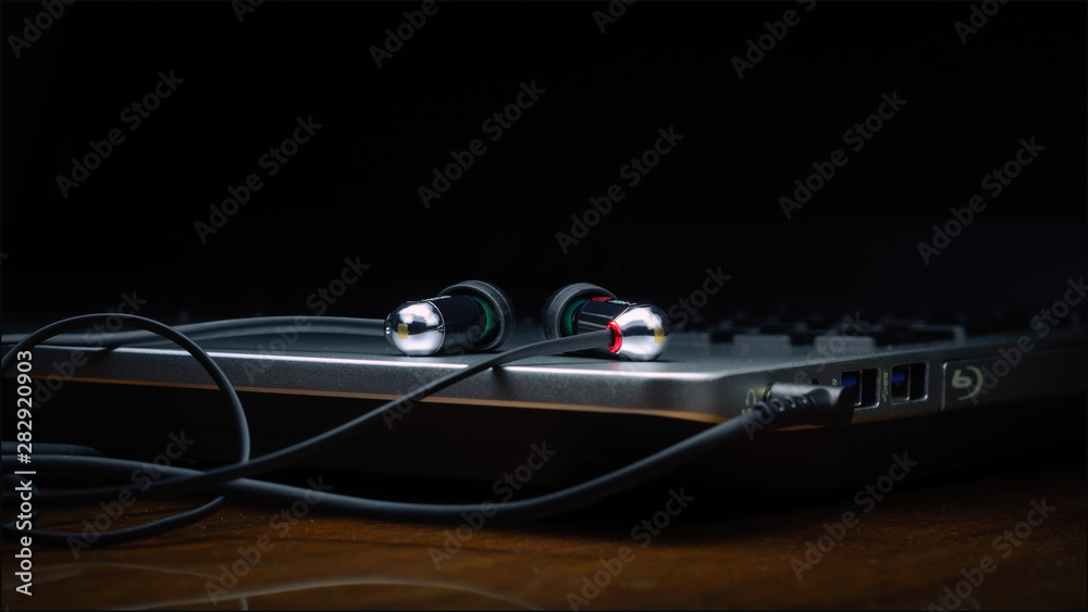 headphones on laptop with black background headphones on laptop with black background