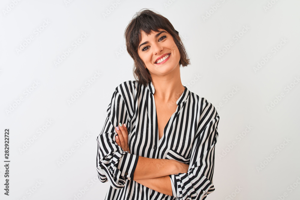 Young beautiful woman wearing striped shirt standing over isolated white background happy face smiling with crossed arms looking at the camera. Positive person. Young beautiful woman wearing striped shirt standing over isolated white background happy face smiling with crossed arms looking at the camera. Positive person.