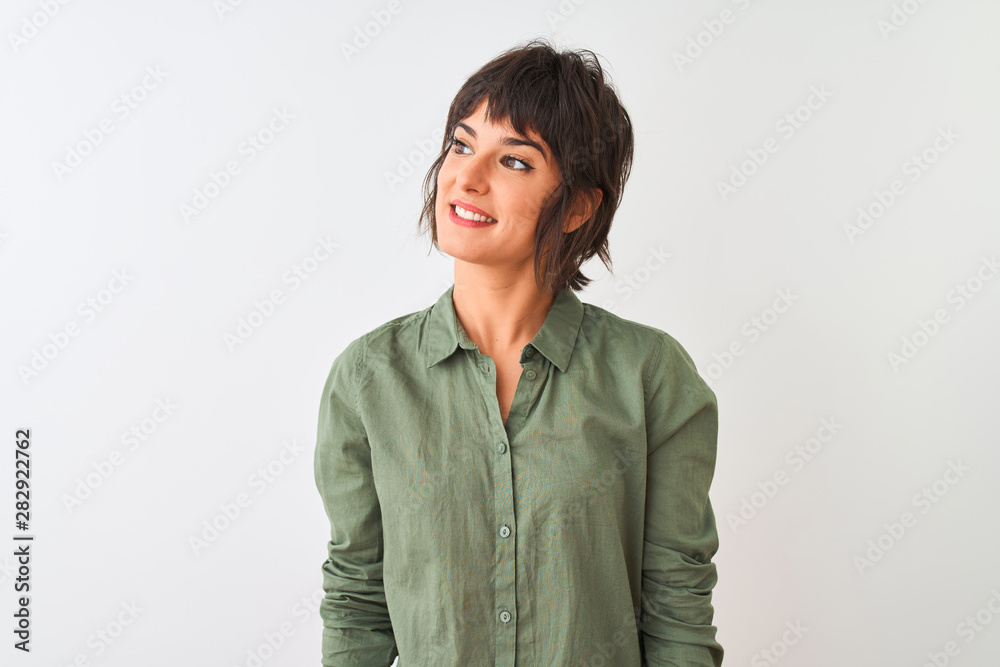 Young beautiful woman wearing green casual shirt standing over isolated white background looking away to side with smile on face, natural expression. Laughing confident. Young beautiful woman wearing green casual shirt standing over isolated white background looking away to side with smile on face, natural expression. Laughing confident.