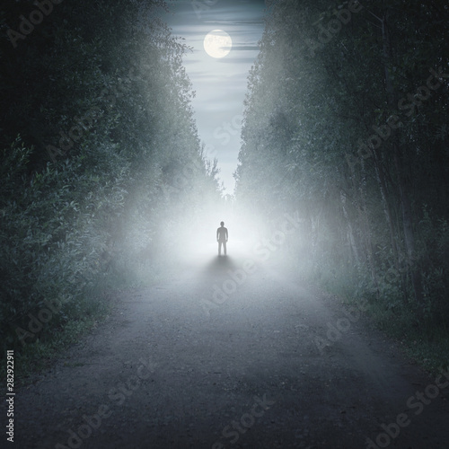 Silhouette of a man in a dark and foggy forest