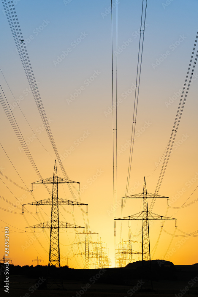 Fototapeta premium Freileitung; Strommasten, Überlandleitung; Netzwerk; Hochspannung; Energie; Elektrizität; Landschaft; Mast; ökologie; Umwelt; Himmel; gelb, Sonne