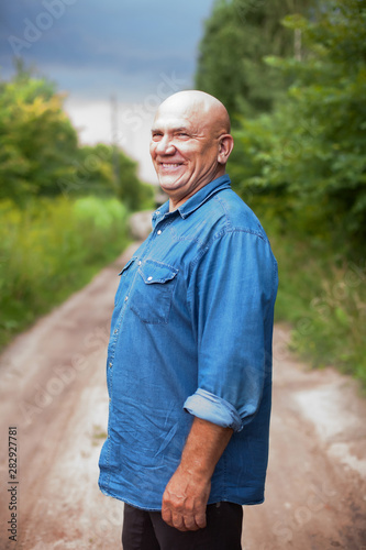 Fototapeta Naklejka Na Ścianę i Meble -  Portrait of  senior farmer in   denim shirt in   village.