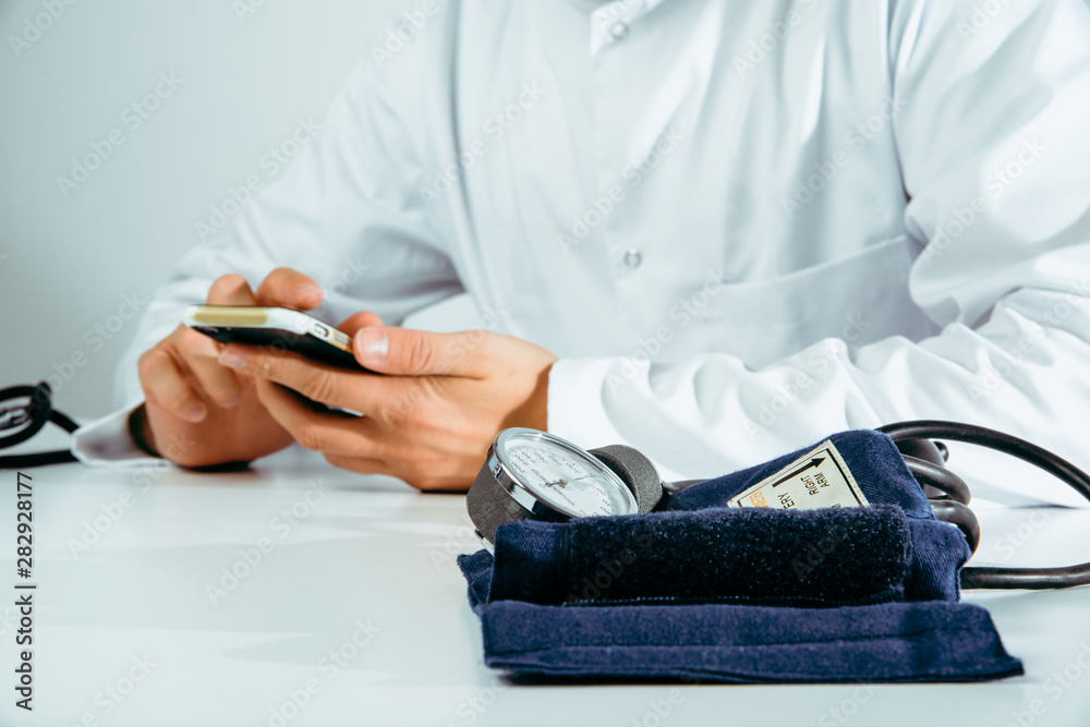 Fototapeta premium The doctor checks the information on the phone. Medical and pharmaceutical concept. The doctor provides information about the patient's health, treatment of diseases, health problems.