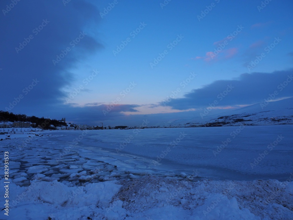winter landscape with blue sky and clouds and a frozen lake in Iceland winter landscape with blue sky and clouds and a frozen lake in Iceland