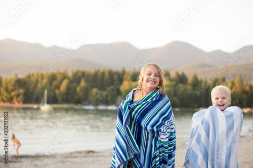 Young boy and girl wrapped in beach towels after swimming in Whitefish Lake photo