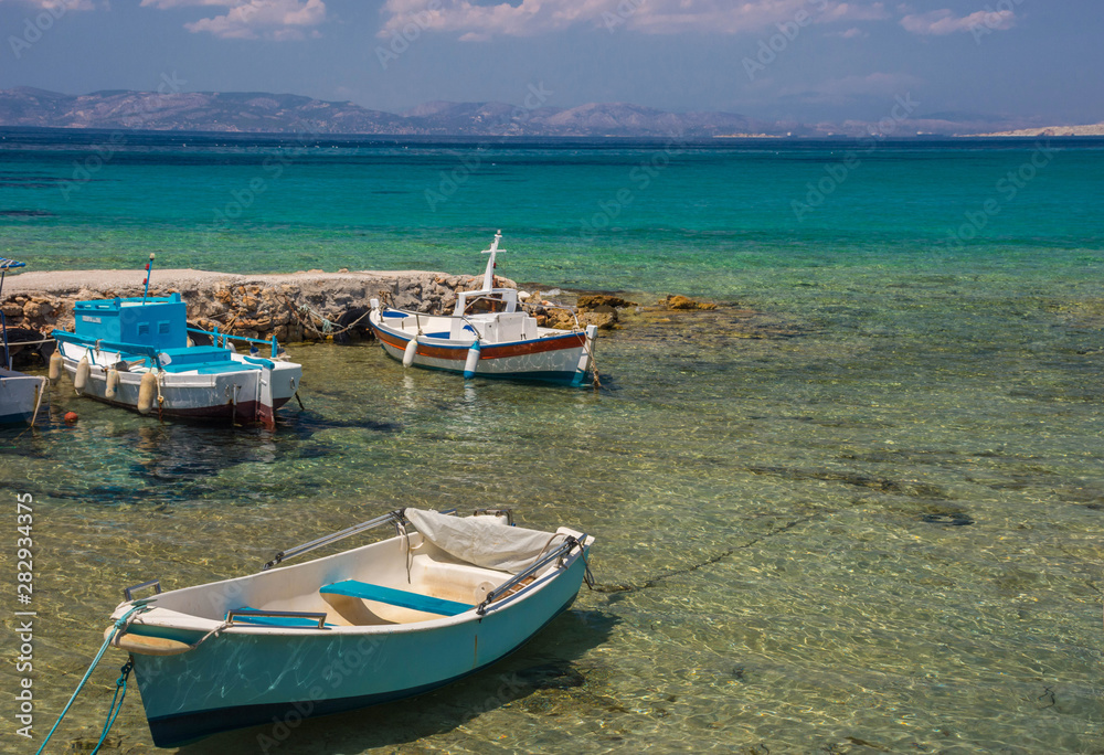 Traditional fishing boats and the clear and blue waters of Mediterranean sea in the Saronic gulf, Greece.