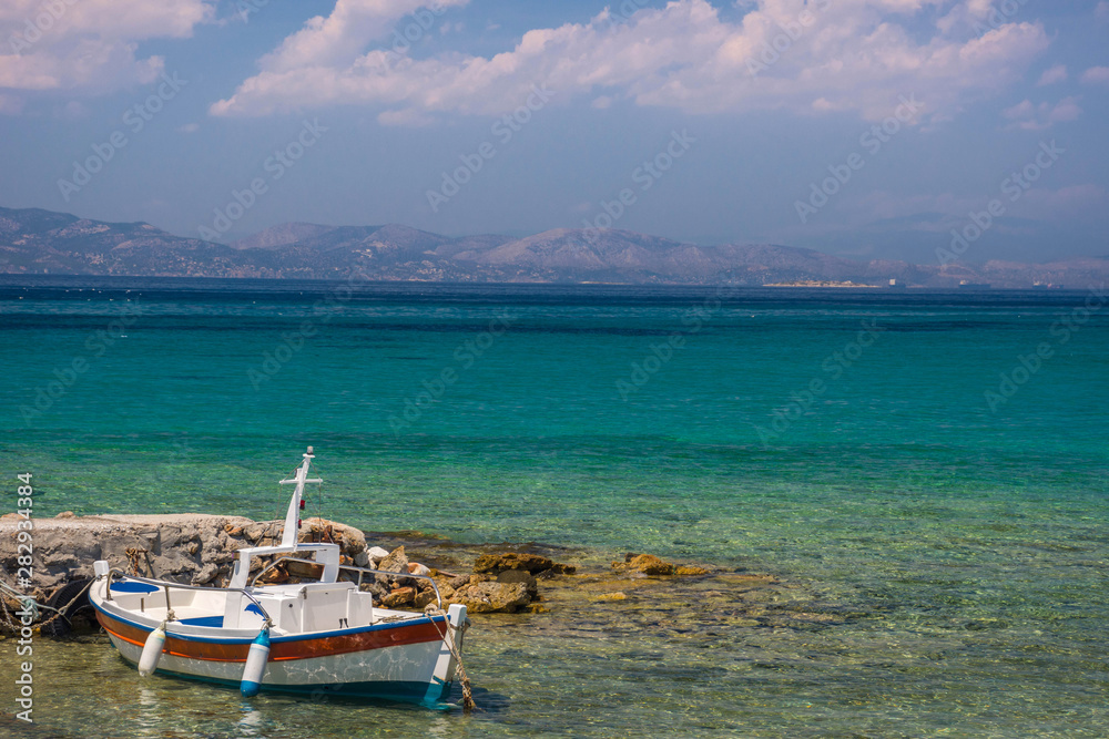 Traditional fishing boat and the clear and blue waters of Mediterranean sea in the Saronic gulf, Greece.