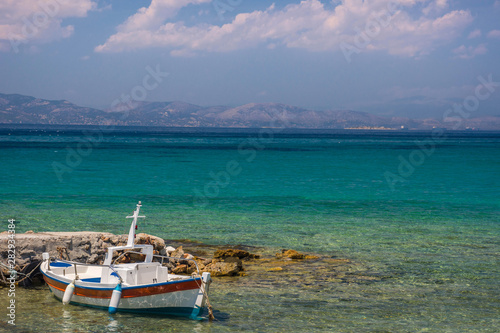 Traditional fishing boat and the clear and blue waters of Mediterranean sea in the Saronic gulf, Greece.