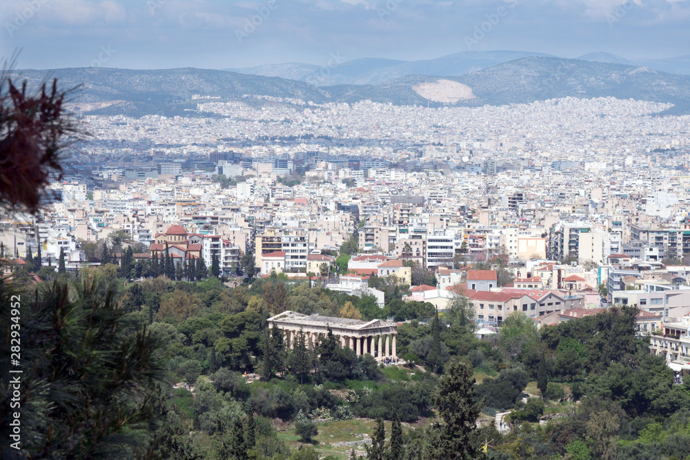 Athens, Greece, April 2019. Ancient Greek ruins among lush green grass. Acropolis, Athens, Greece. Beautiful views of the Greek capital  and the Temple of Hephaestus from the slopes of the Acropolis.
