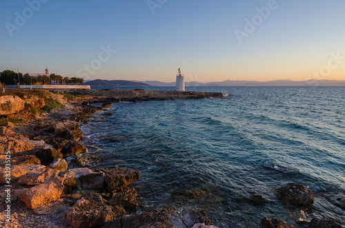 Wallpaper Mural Wild coast of the Aegina island and the old small lighthouse in the background, Saronic gulf, Greece, at sunset. Torontodigital.ca