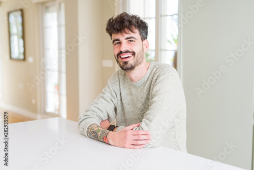 Handsome young man smiling cheerful at the camera with crossed arms and a big smile on face showing teeth © Krakenimages.com