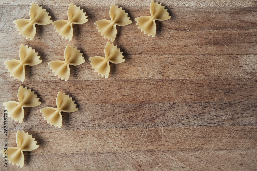 Farfalle on a wooden background. Place for text. Texture wood with notches