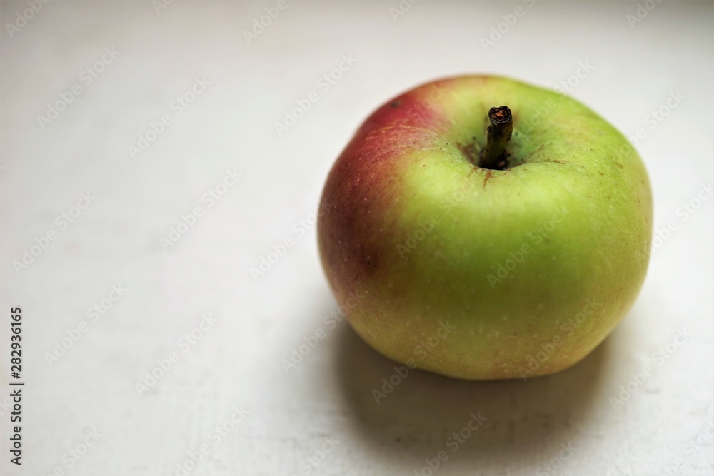 small green apple on the white table small green apple on the white table