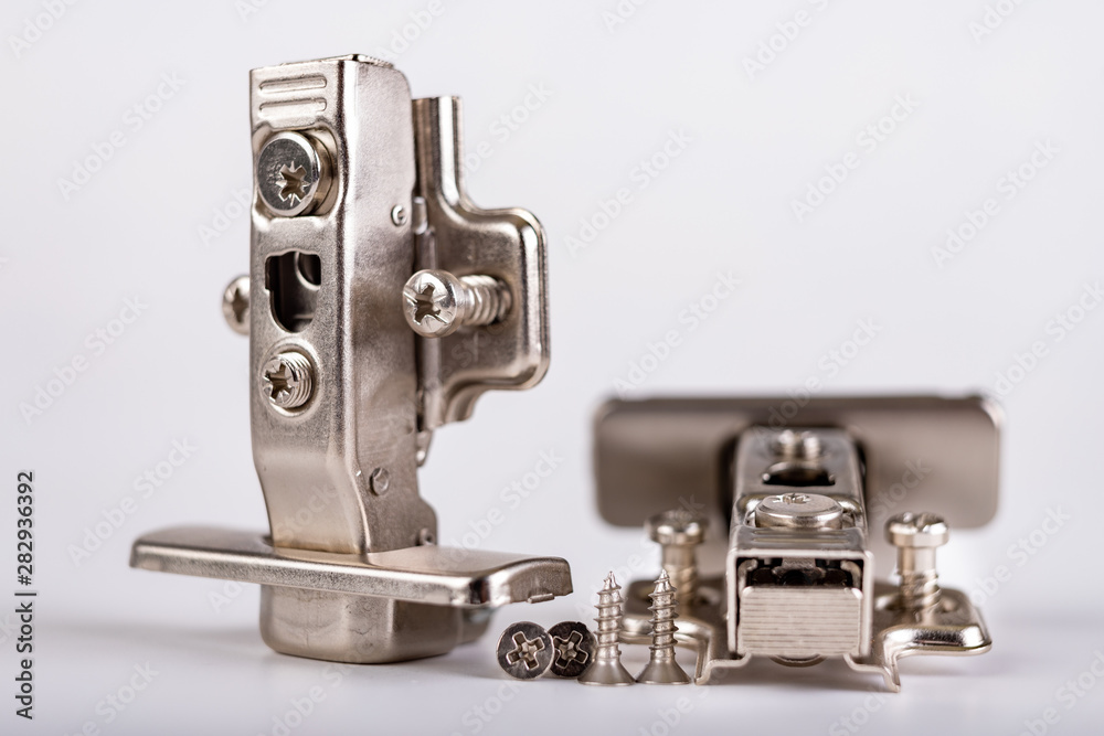 Furniture hinges on a white table. Furniture accessories for carpenters. Furniture hinges on a white table. Furniture accessories for carpenters.