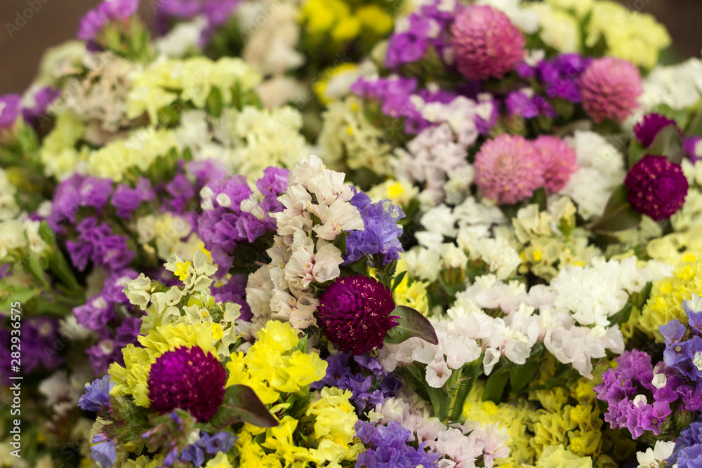 Limonium, Gomphrena globosa - many colorful flowers in a bouquet. Yellow, white, blue and pink dried flowers flowers, background Limonium, Gomphrena globosa - many colorful flowers in a bouquet. Yellow, white, blue and pink dried flowers flowers, background