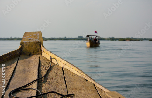 Vászonkép A front of wooden boat on a river near Kratie in Cambodia