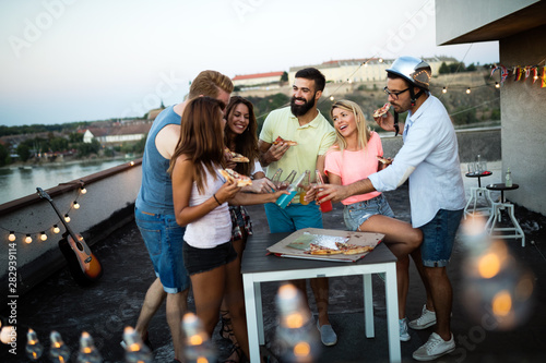Group of happy friends having party on rooftop
