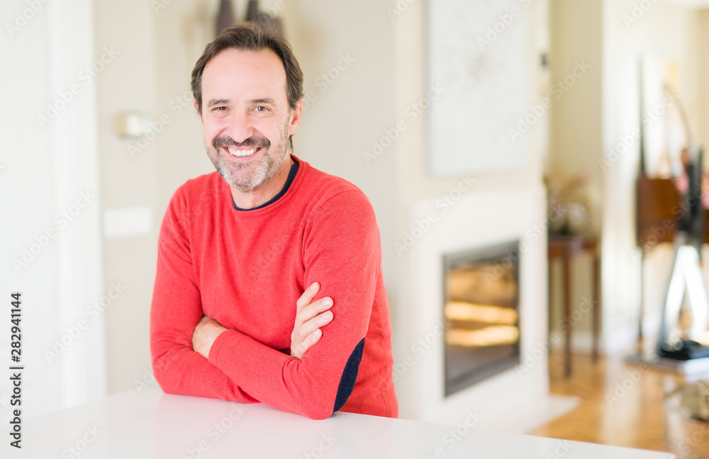 Handsome middle age man smiling looking at the camera at home Handsome middle age man smiling looking at the camera at home
